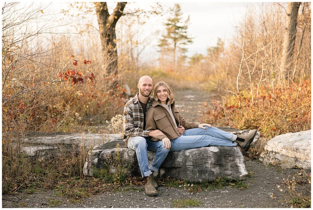 Couple sitting on a rock smiling at the camera