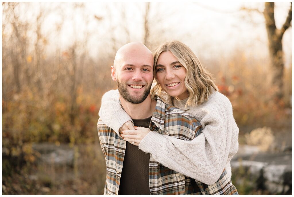 Couple smiling at camera, woman on man's back.
