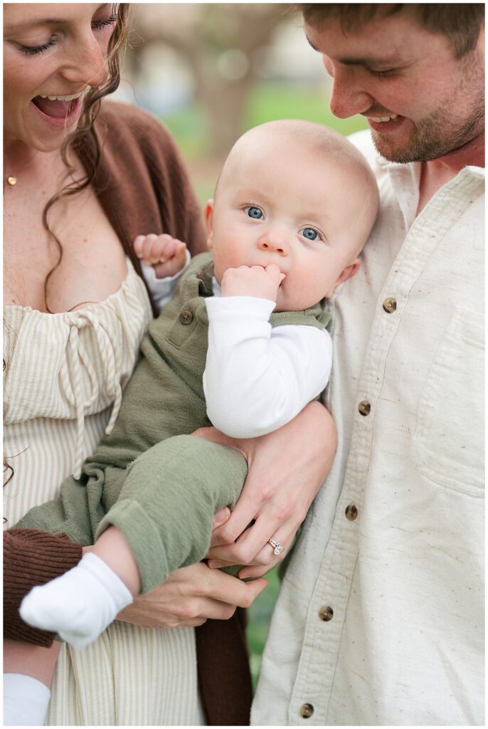 baby chewing on hand giggling at camera