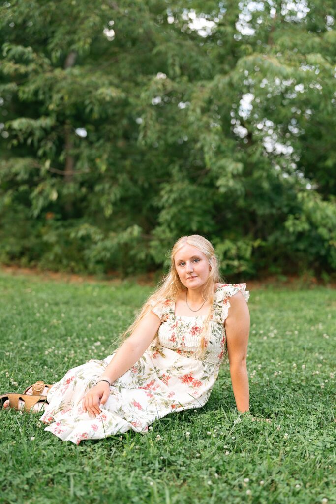 senior girl sitting in grass looking at camera