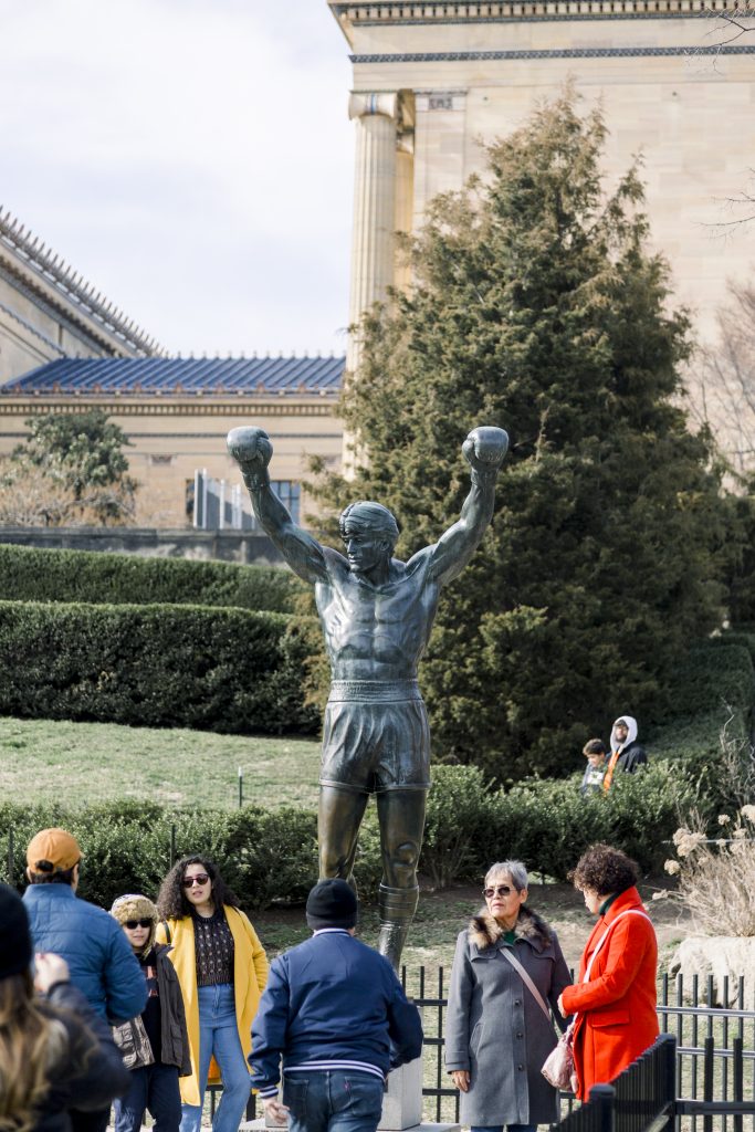 rocky statue in philadelphia with lots of people around it