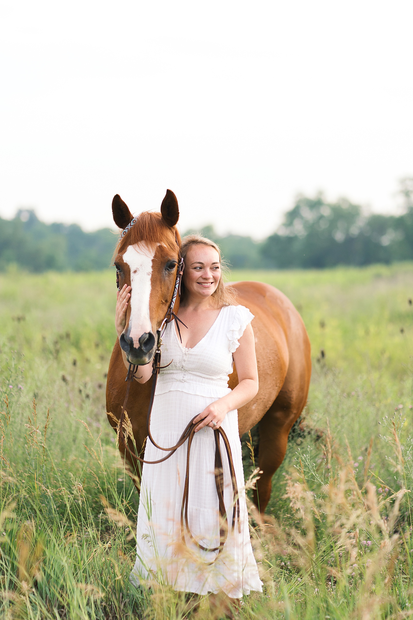 girl and horse stand in field for portraits